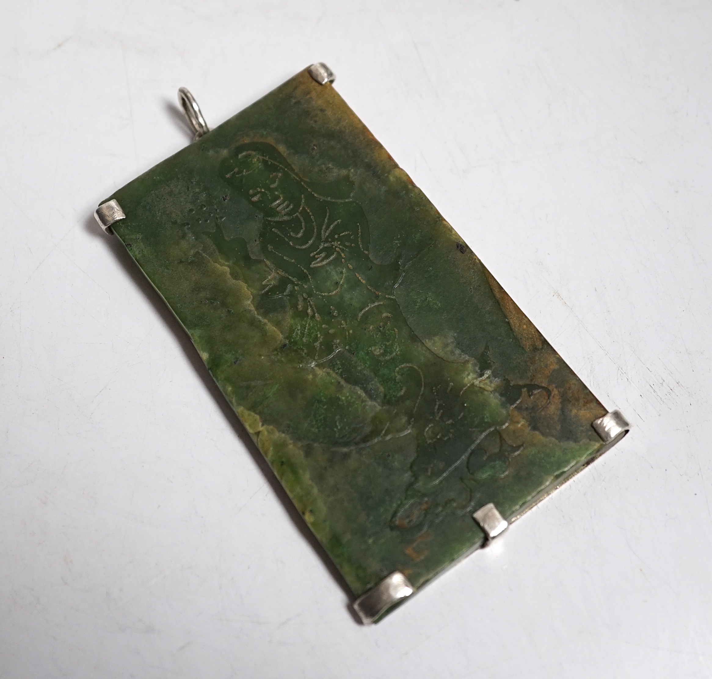 A Chinese carved spinach green jade panel, 9cms high.